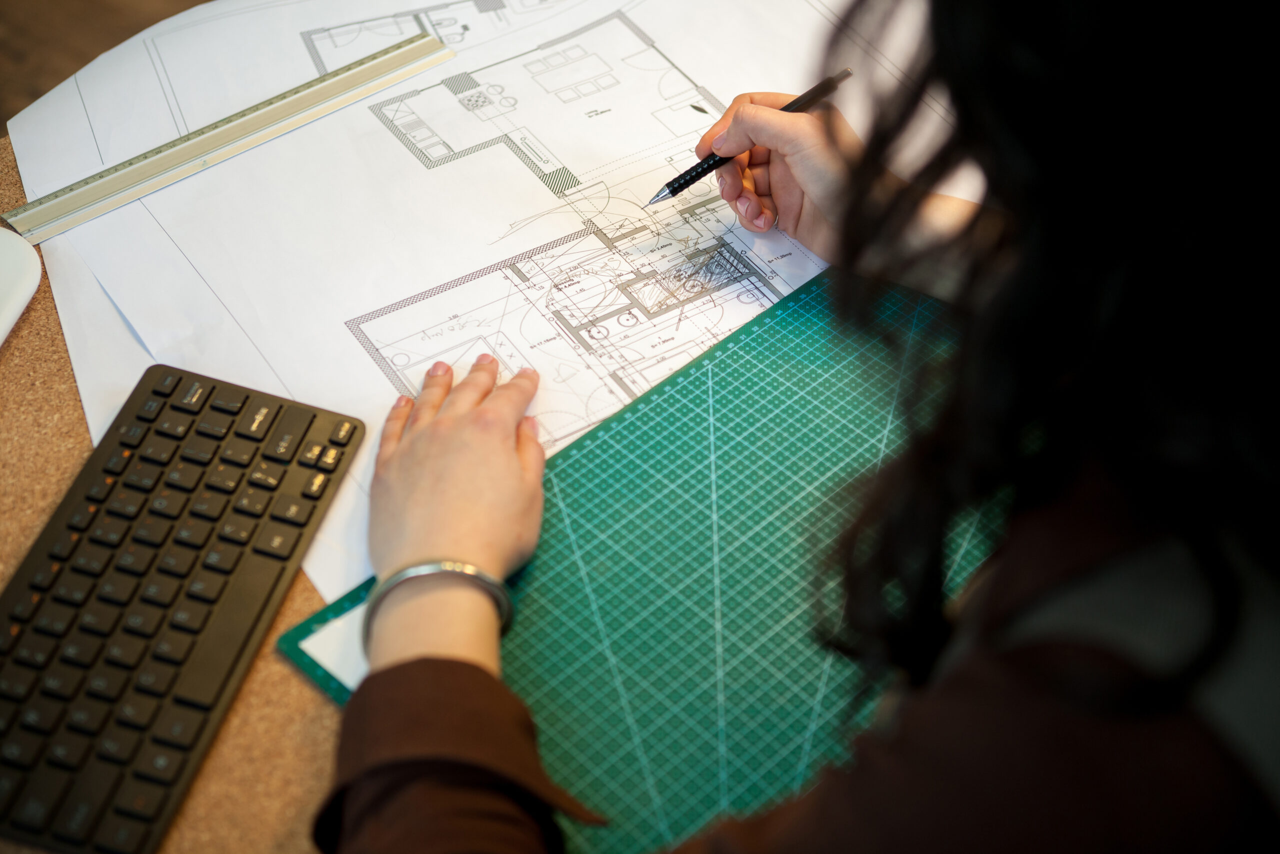Architect working on blueprints on her table osoba obliczajaca powierzchnie do malowani